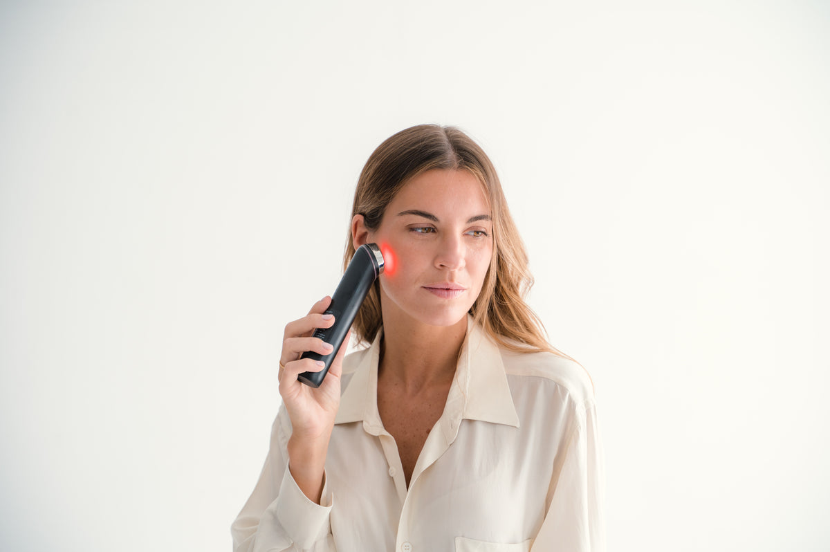 Mujer utilizando el dispositivo Medicube AGE-R Booster Pro en la mejilla, mostrando su aplicación facial y uso cotidiano.