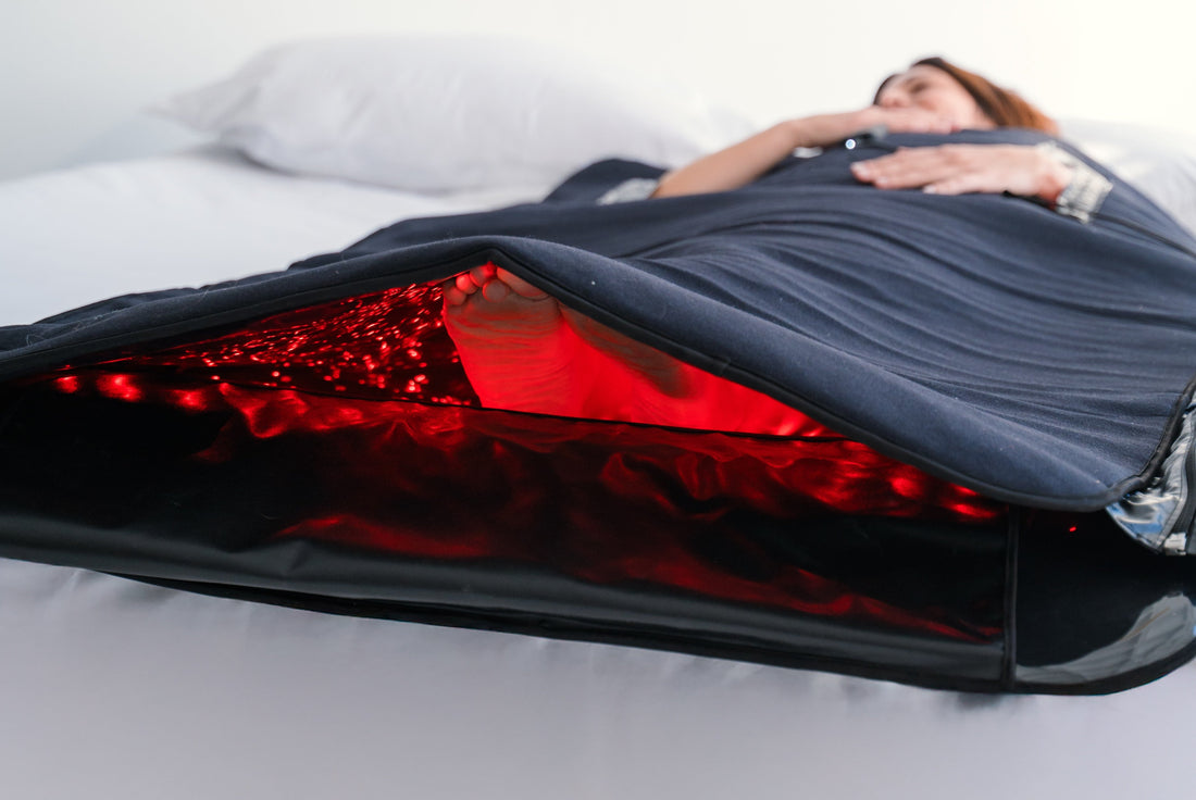 Mujer dentro de manta de luz roja e infrarroja disfrutando y mejorando su salud