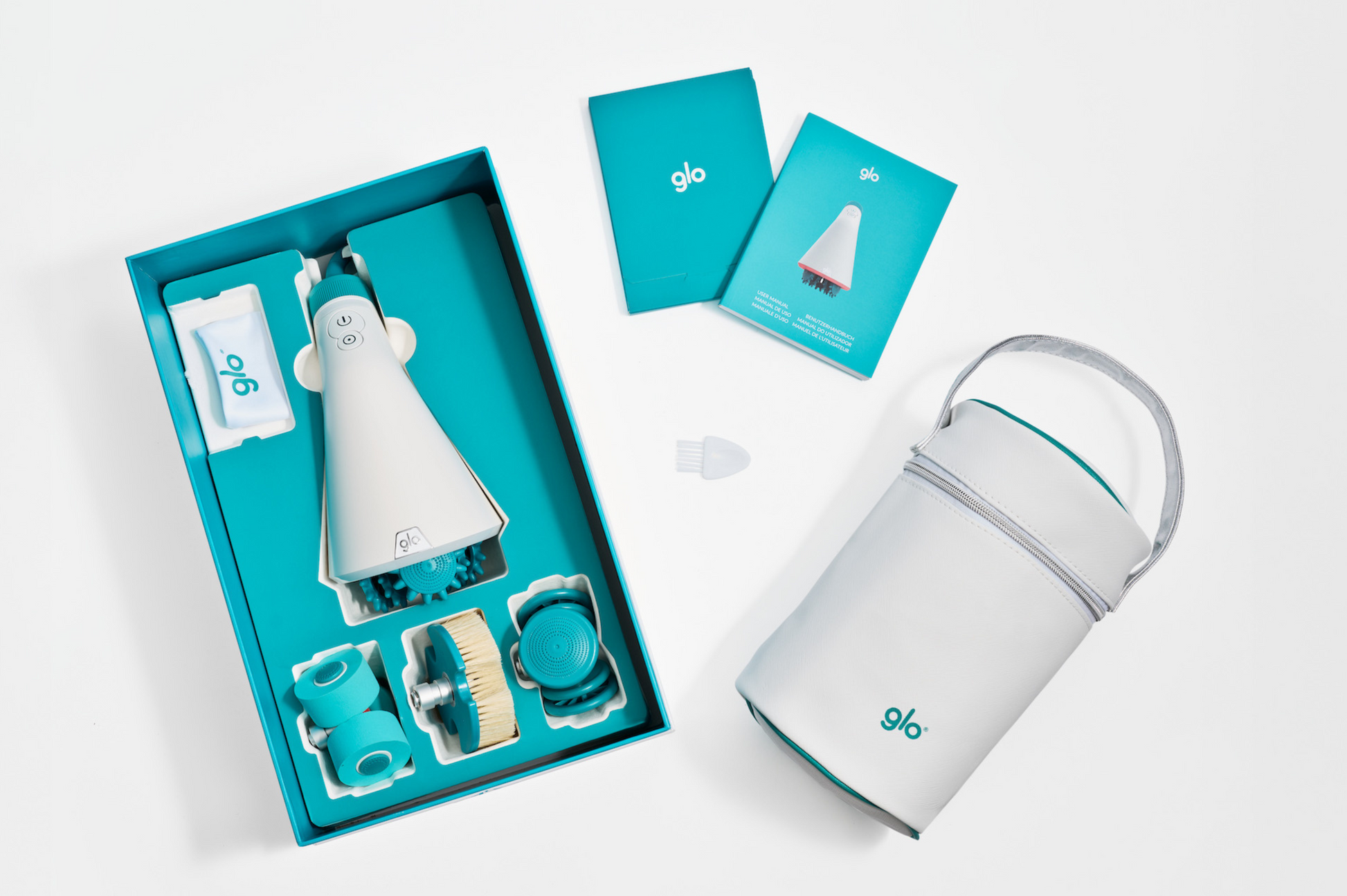 SET GLO 910 PRO CON DISPOSITIVO DE MASAJE, CABEZALES, MANUALES Y NECESER ORGANIZADOR MOSTRADOS EN CAJA ABIERTA SOBRE FONDO BLANCO