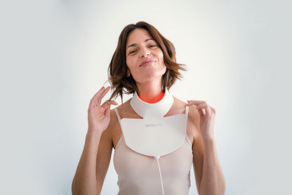 Mujer utilizando el dispositivo Silicone LED Neck con luz LED roja para el cuidado de la piel del cuello y escote.