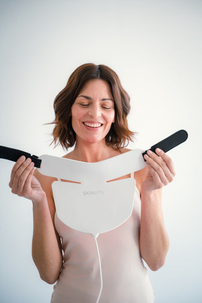 Mujer mostrando el dispositivo Silicone LED Neck de silicona flexible con cierre ajustable para tratamiento LED en cuello y escote.