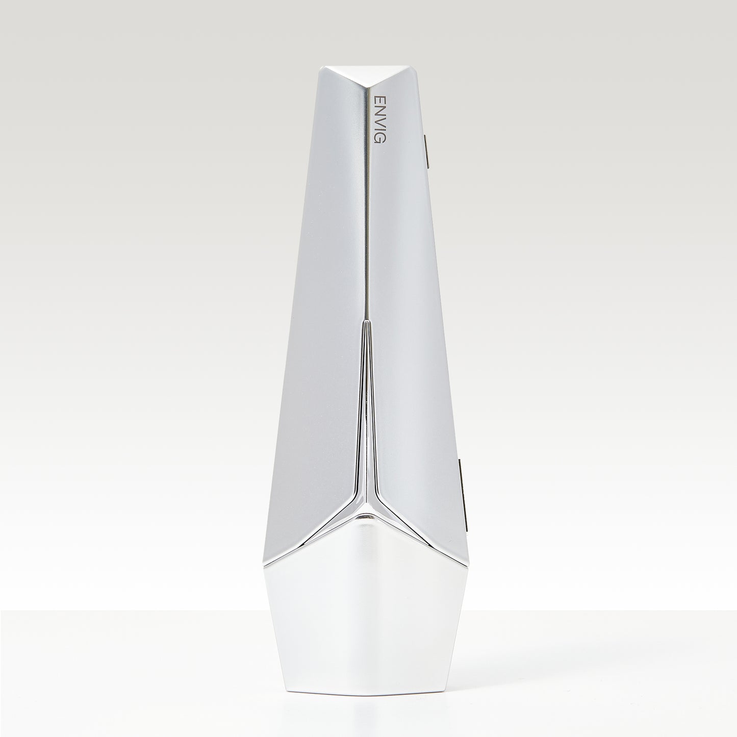 Dispositivo facial Envig Edge con diseño cromado y líneas elegantes, tecnología de radiofrecuencia fraccionada para mejorar textura y firmeza.